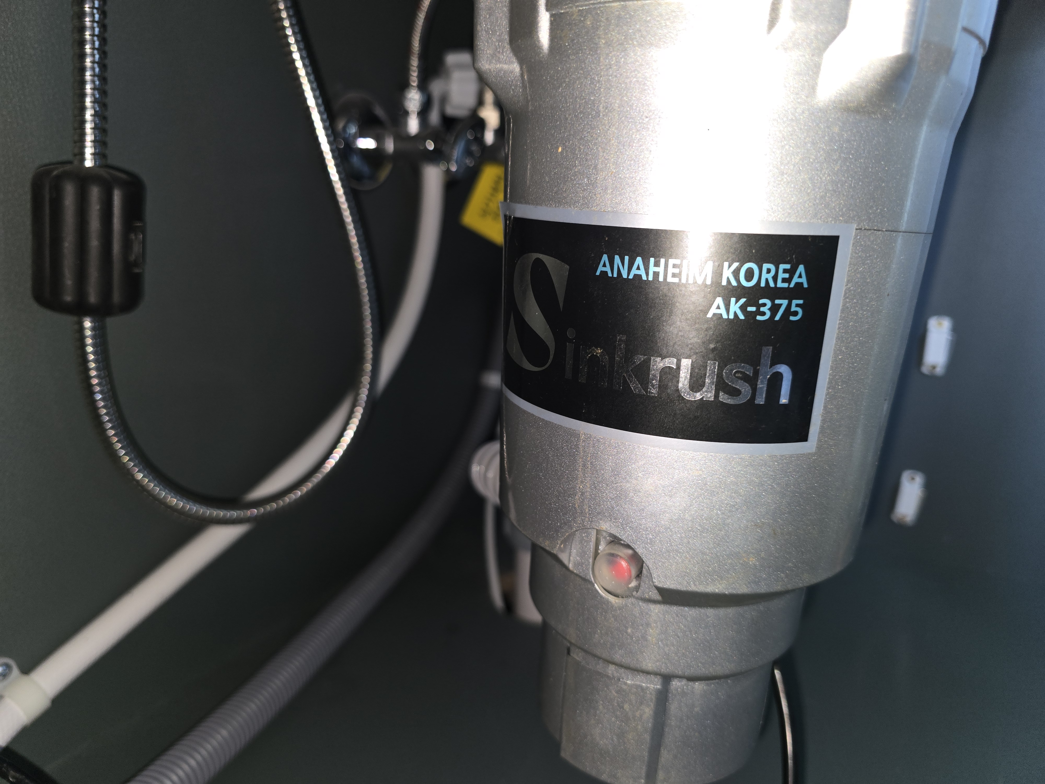 싱크대 아래 설치된 싱크러쉬 디스포저 본체 근접 사진